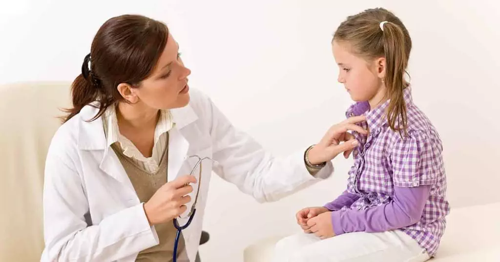 Photo of Female doctor examining child holding stethoscope