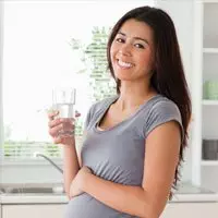 Photo of pregnant woman drinking a glass of water