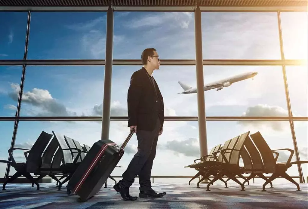 Photo of man dragging luggage through an airport terminal
