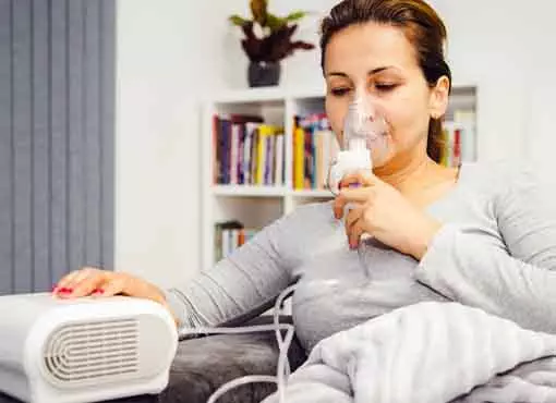 Photo of older woman taking a nebulizer treatment