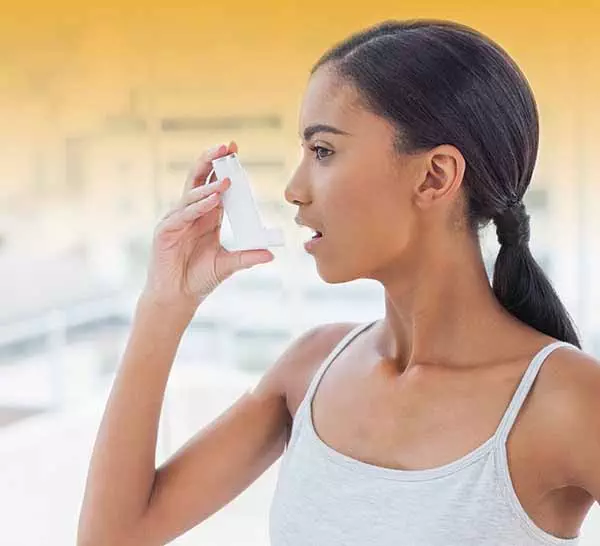Photo of young woman with an asthma inhaler