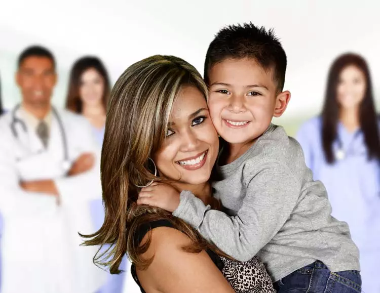 Latino mom and son at hospital with doctors and nurses in the background