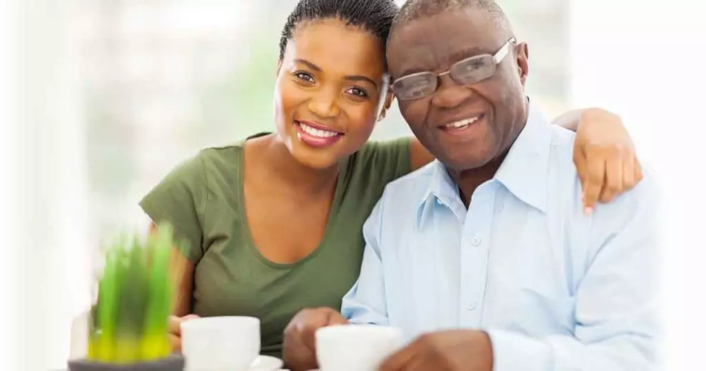 Photo of young adult african girl and father having coffee