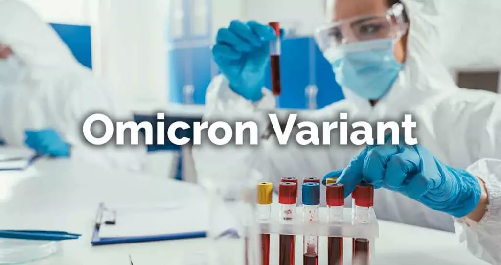 person in a medical lab holding a vial with the words Omicron Variant over the image