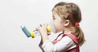 Photo of little girl using her holding chamber and her inhaler