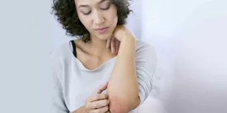 woman scratching her elbow