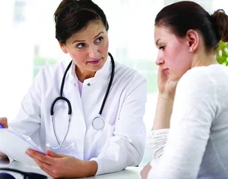 Photo of female doctor consulting with a young female patient