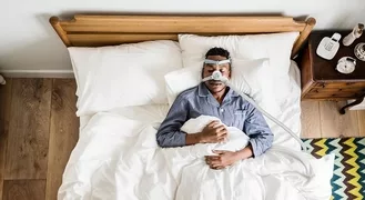 Photo of man sleeping with a sleep apnea machine attached to his face