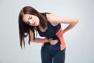 photo of woman having pain in stomach over gray background