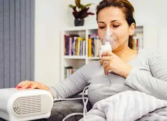 Photo of older woman taking a nebulizer treatment