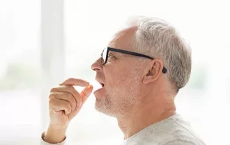 Photo of a man taking a pill