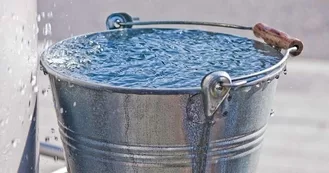 Photo of a metal bucket overflowing with water