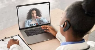 Photo of African doctor wear headset consult female black patient make online webcam video call on laptop screen. Telemedicine videoconference remote computer app virtual meeting.