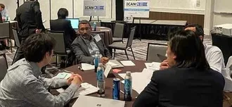 photo of attendees of the in-person ICAN conference around a table