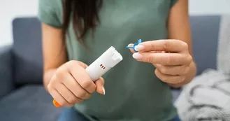 Woman pulling cap off auto-injector