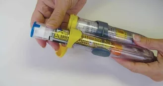 Woman's hands holding two epinephrine autoinjectors