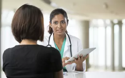 Photo looking over the shoulder of a patient having a conversation with a doctor