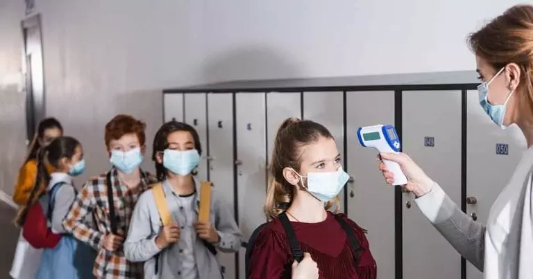 Photo of School Children with masks getting their temperature checked